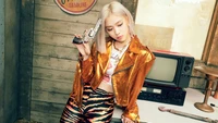 Ryujin from ITZY in a bold, stylish outfit, holding a toy gun against a retro backdrop.