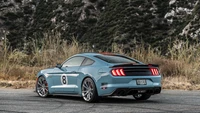 2023 Shelby Mustang GT dans une finition bleue frappante, mettant en valeur des lignes épurées, des jantes en alliage et une posture dynamique sur fond naturel.