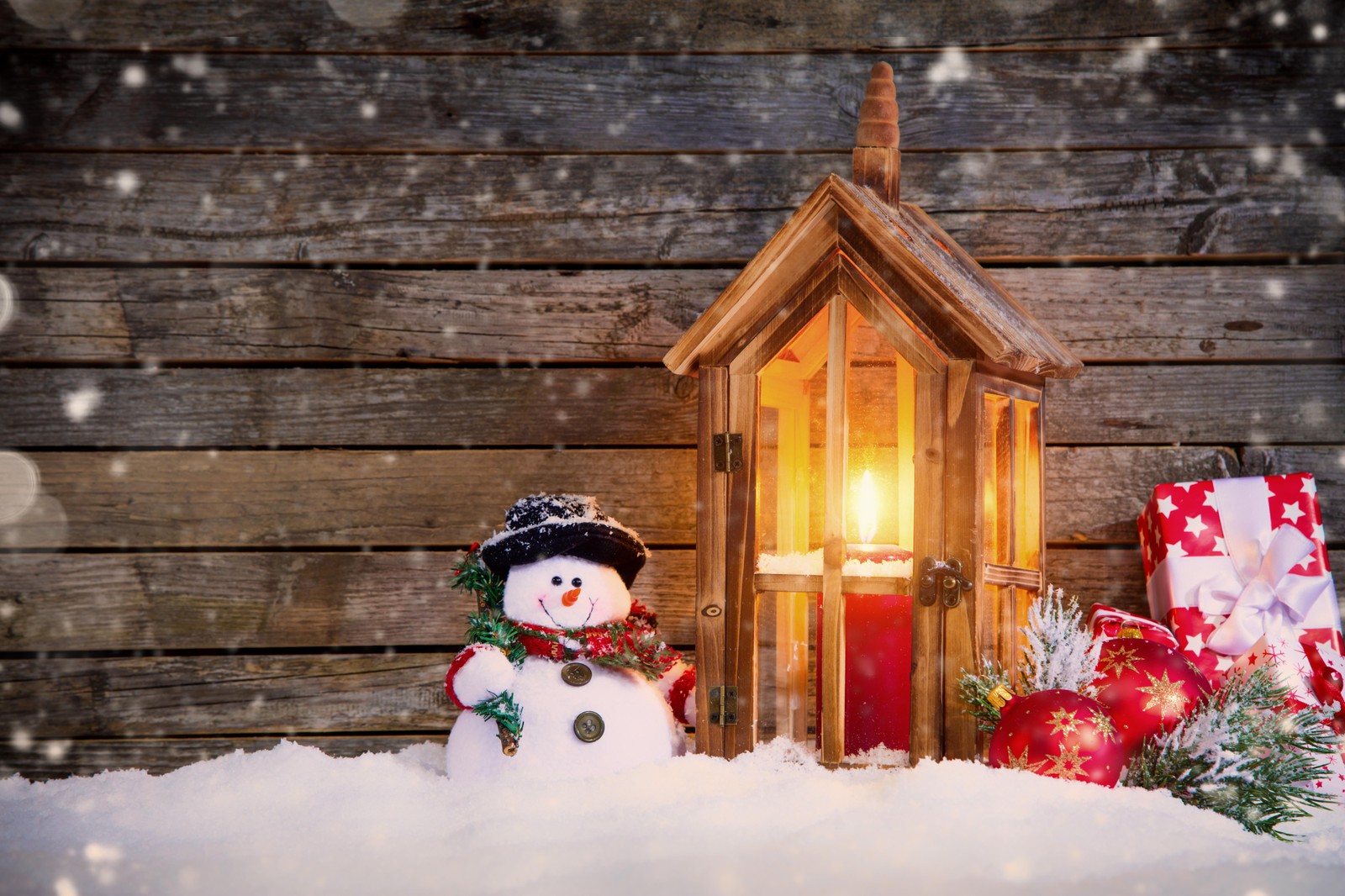 A close up of a snowman with a lantern and presents (christmas day, snowman, christmas decoration, christmas ornament, snow)