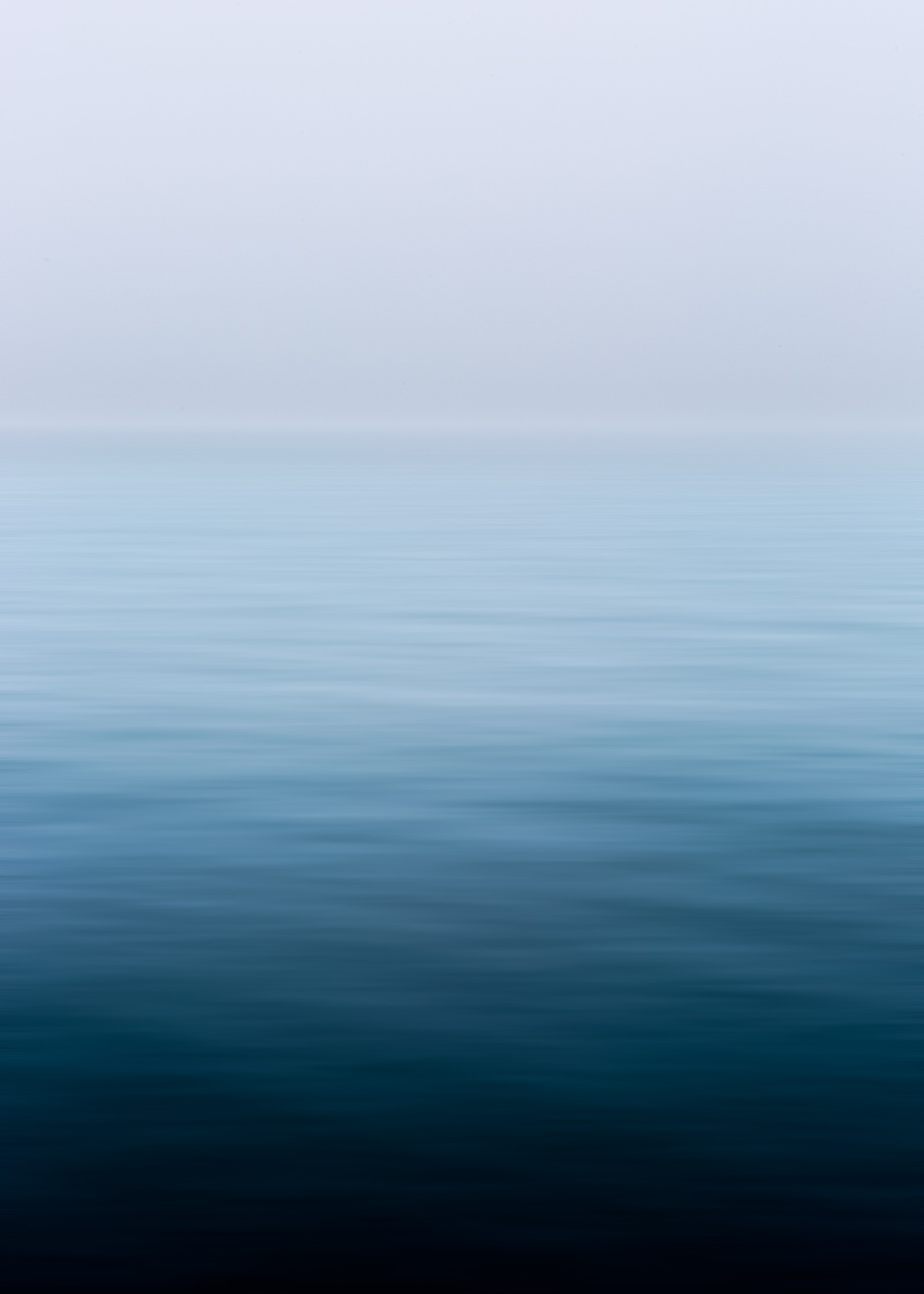 Vue aérienne d'un plan d'eau avec un bateau au loin (mer, horizon, bleu, eau, calme)