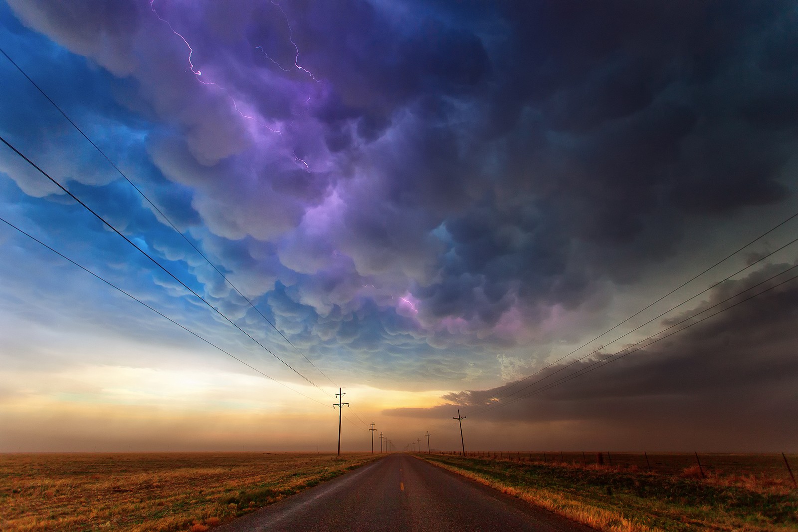 Un gros plan d'une route avec des lignes électriques et une tempête dans le ciel. (texas, nuage, horizon, atmosphère, matin)