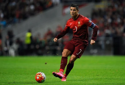 Cristiano Ronaldo in action, dribbling the ball on the field during a soccer match for Portugal.