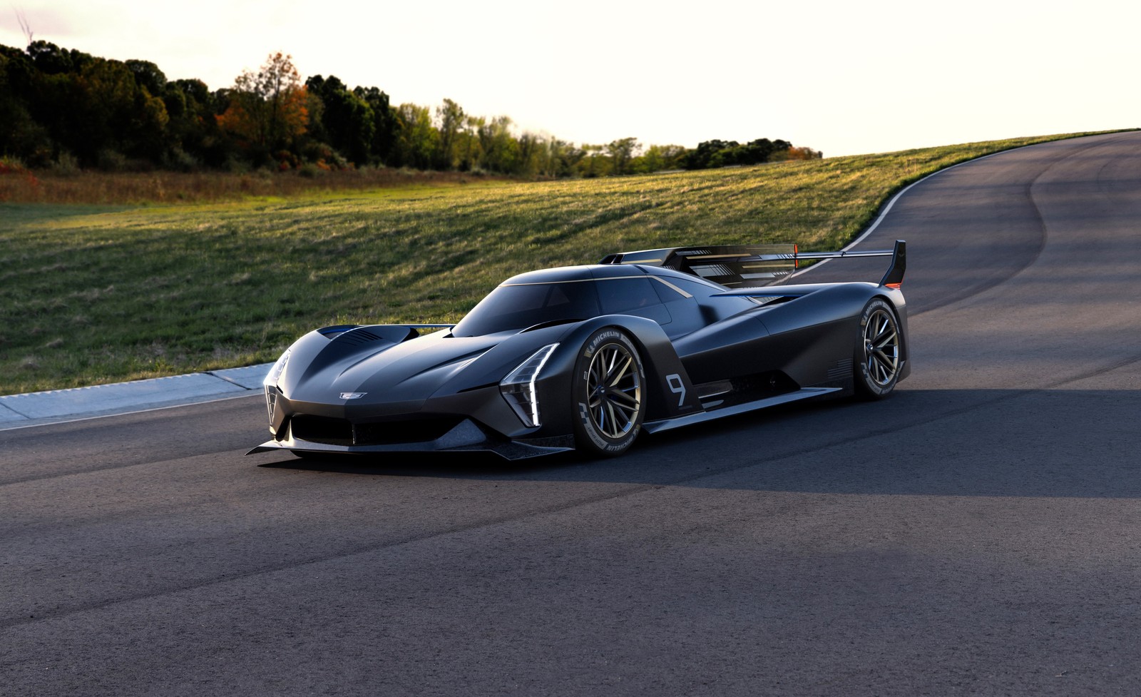 Ein schwarzer sportwagen, der auf einer straße neben einem feld fährt (cadillac projekt gtp, cadillac project gtp, hypercar, prototyp, hypercars)