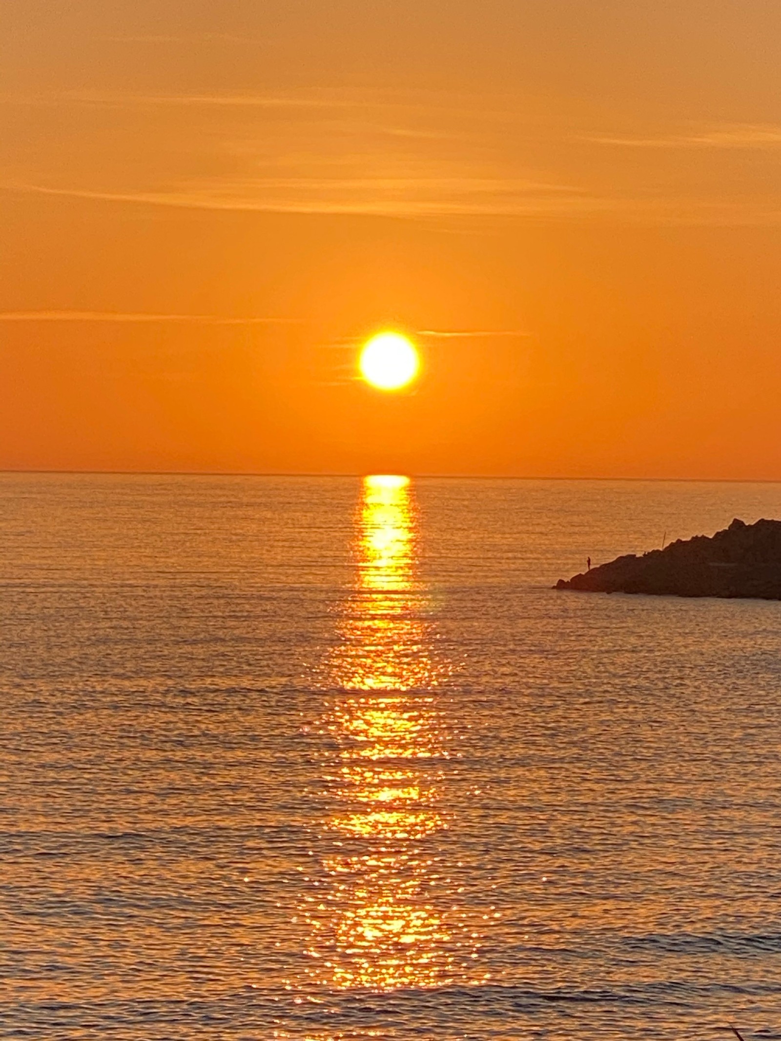 Atardecer sobre el océano con un barco a lo lejos (horizonte, sol, agua, recursos hídricos, atmósfera)