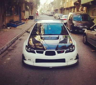 Subaru WRX personalizado com um design preto e branco marcante estacionado em uma rua estreita.