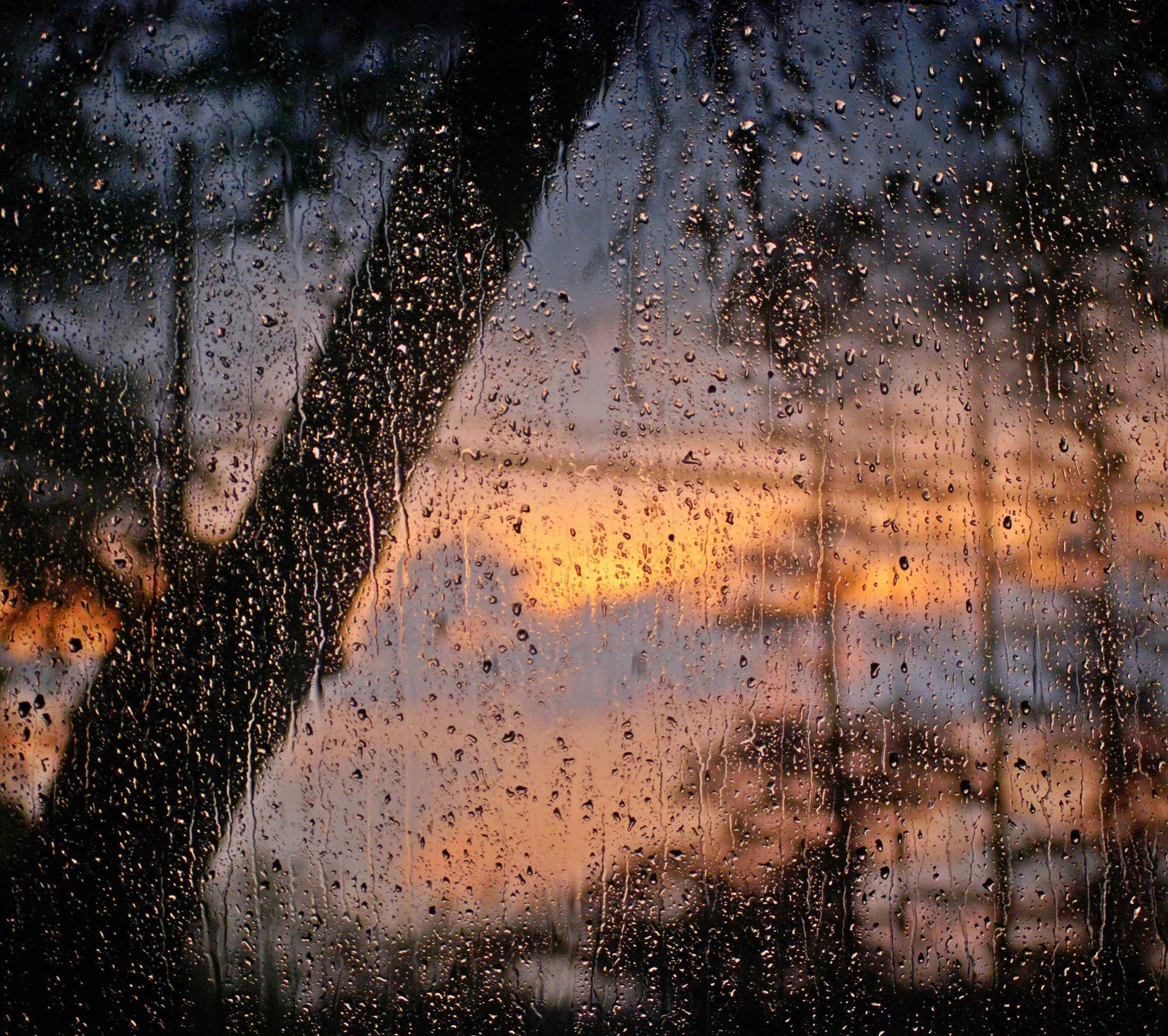 Vista de um pôr do sol através de uma janela coberta de chuva (gota, vidro, macro, céu, por do sol)