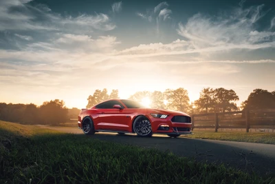 Ford Mustang GT rouge sur une route de campagne pittoresque au coucher du soleil