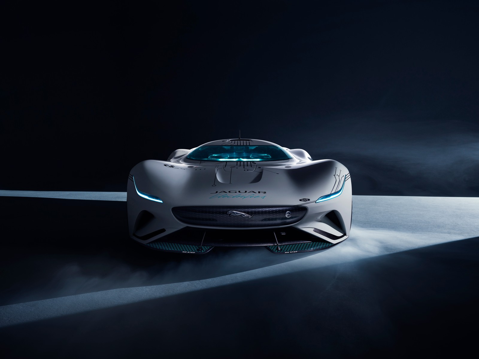 Un primer plano de un coche en una habitación oscura con humo saliendo de él (jaguar vision gran turismo sv, 5k, hipercoches, coches conceptuales, fondo oscuro)