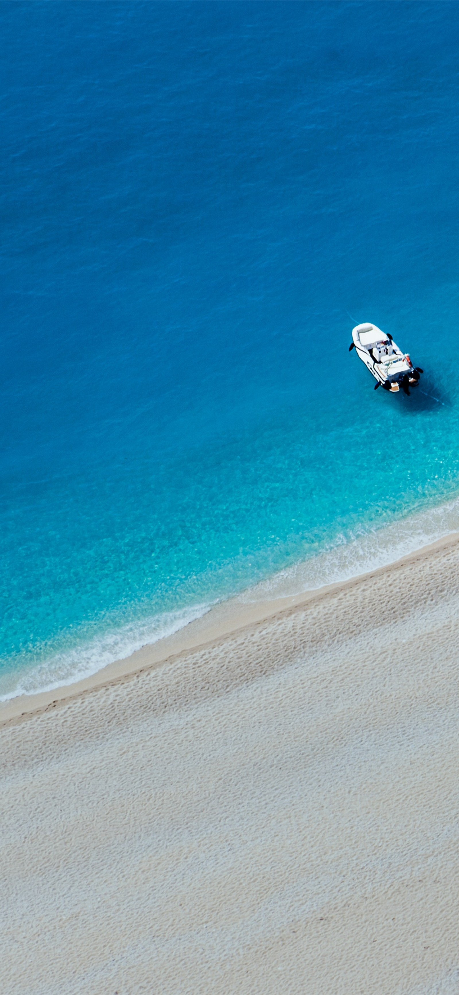 Il y a un bateau qui est assis dans l'eau sur la plage (mer, eau, capuche, bleu, plage)