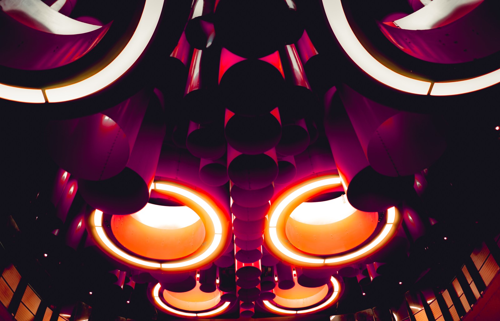 A close up of a ceiling with a lot of lights (orange, purple, pink, pattern, illustration)