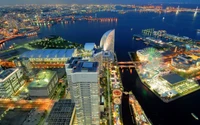 Un paisaje urbano vibrante por la noche que muestra la iluminada Torre Landmark de Yokohama, atracciones frente al mar y un diseño urbano bullicioso a lo largo de la vía fluvial.