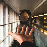 Mano sosteniendo un reloj elegante en un entorno moderno