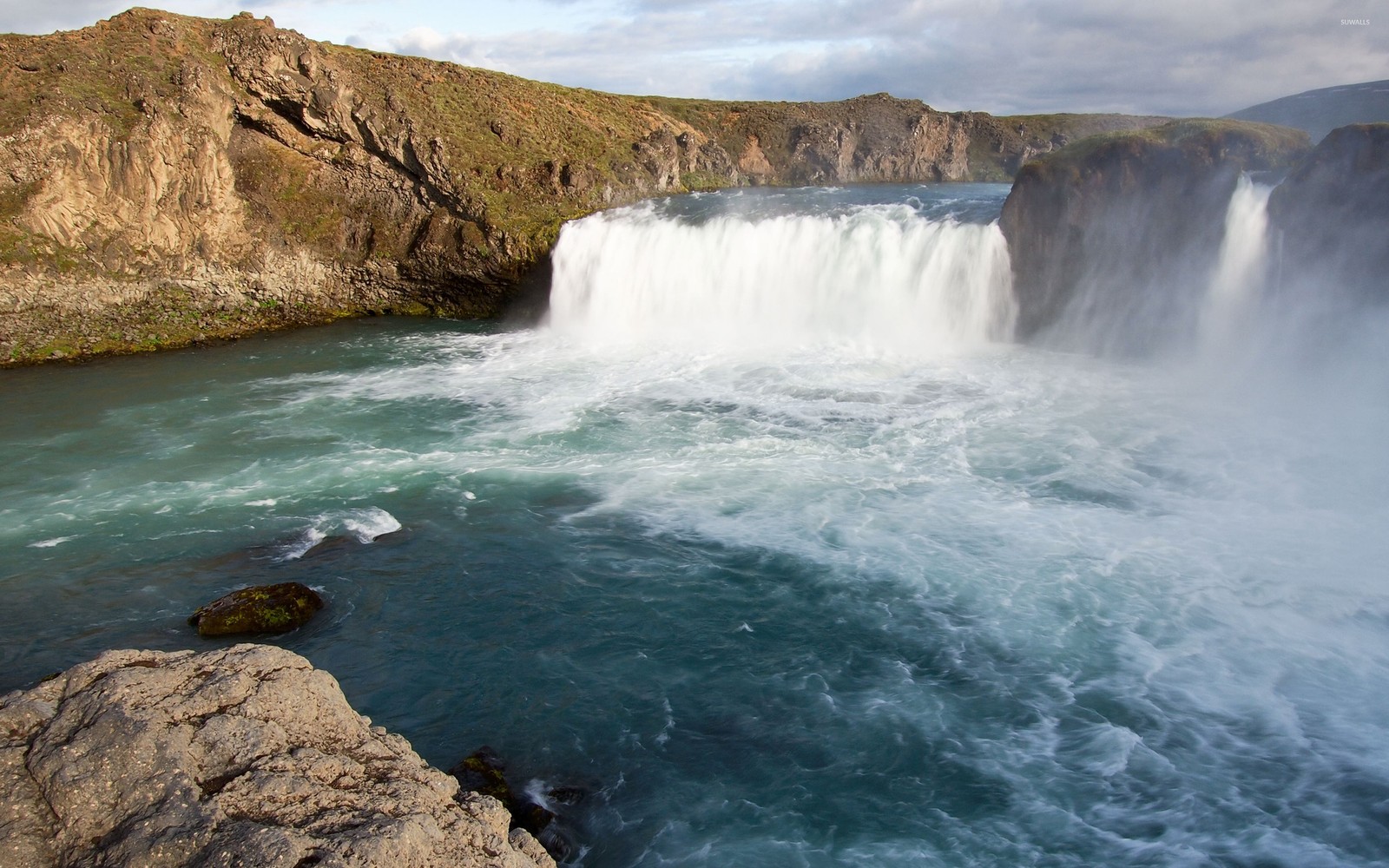 Una cascada árabe con agua fluyendo sobre rocas y un acantilado (cascada, cauce, cuerpo de agua, recursos hídricos, agua)