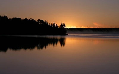 Gelassener Sonnenaufgang über ruhigen Gewässern