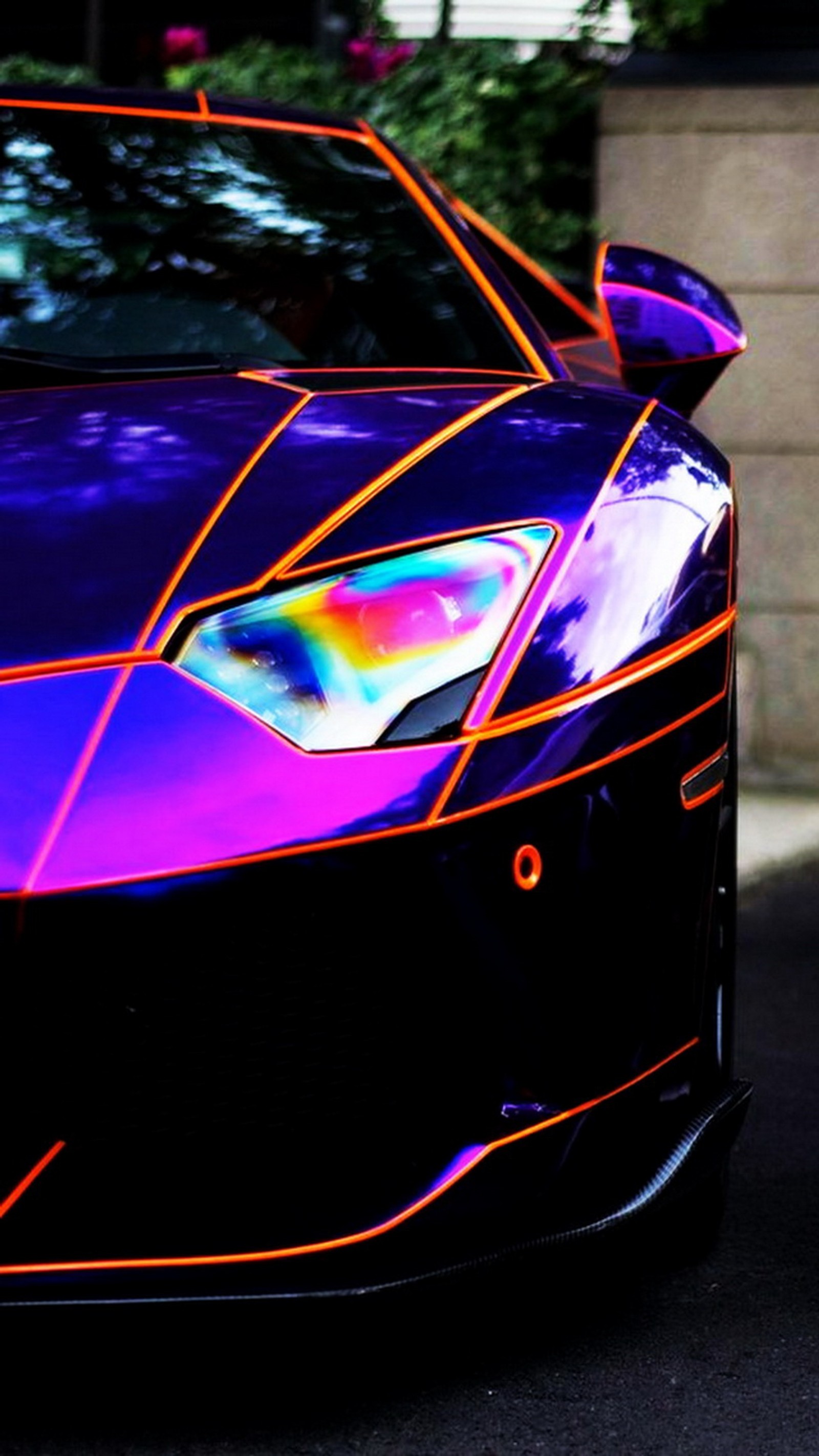 Gros plan d'une voiture de sport violet et orange garée dans la rue (lamborghini)