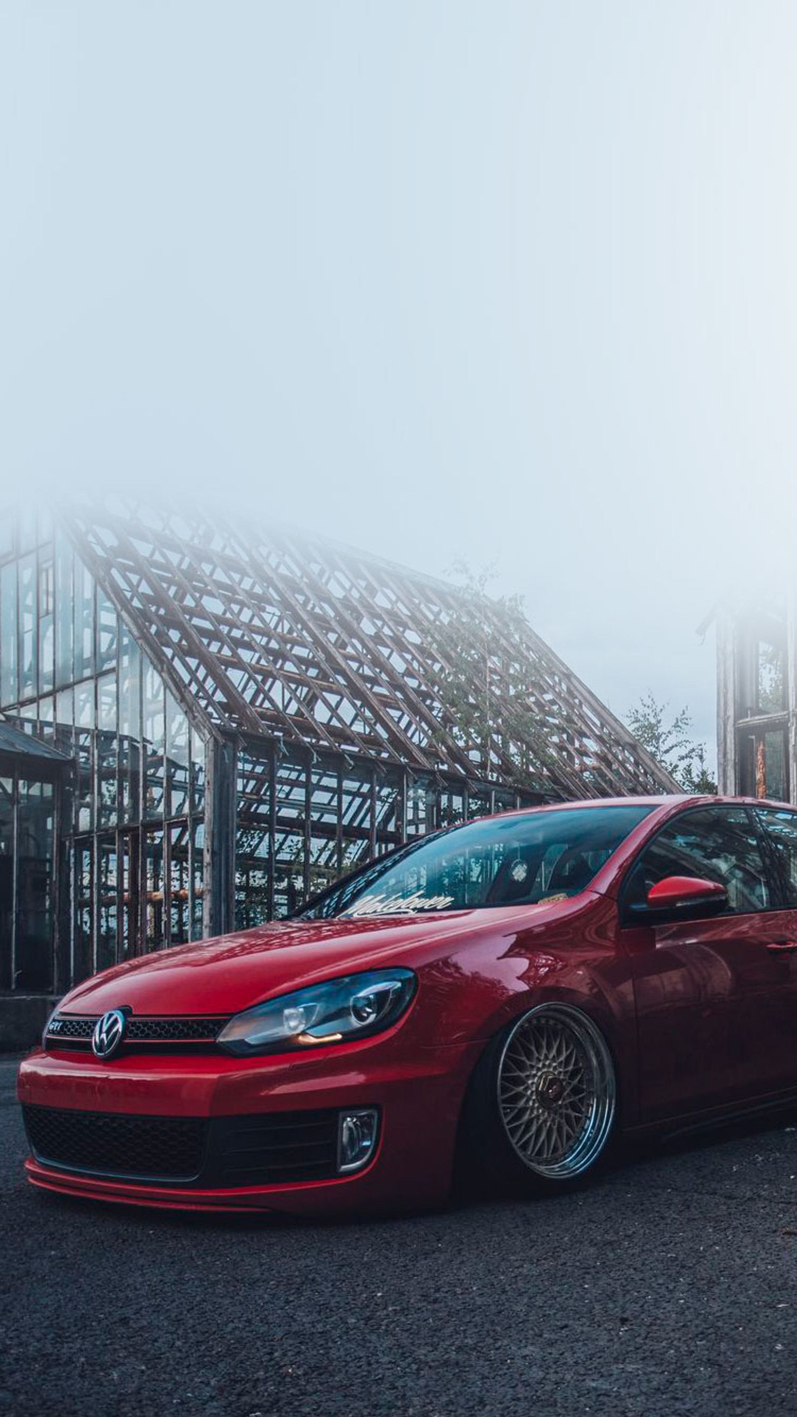 Carro vermelho árabe estacionado em frente a um prédio com uma grande estrutura ao fundo (golfe, mk6, vermelho, volkswagen, vw)