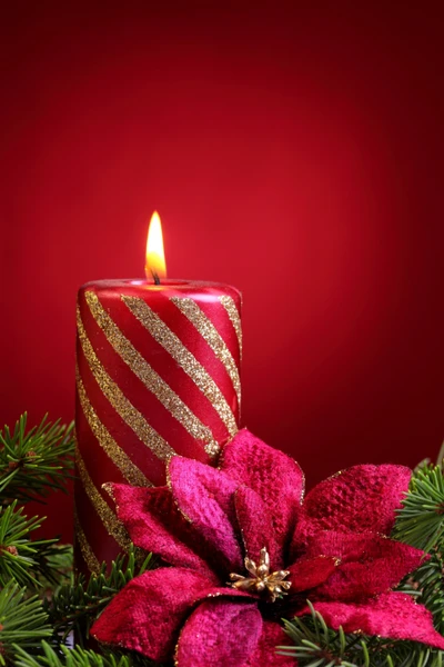 Festliche Kerze mit glitzernden Streifen und roter Weihnachtsstern