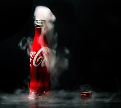 Coca-Cola-Flasche umgeben von Dampf