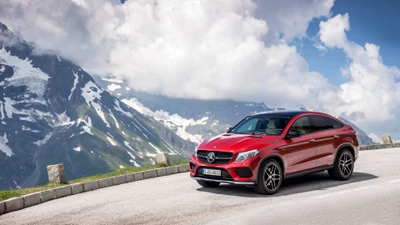 Red Mercedes-Benz GLE Coupe parked on a scenic mountain road under a dramatic sky.