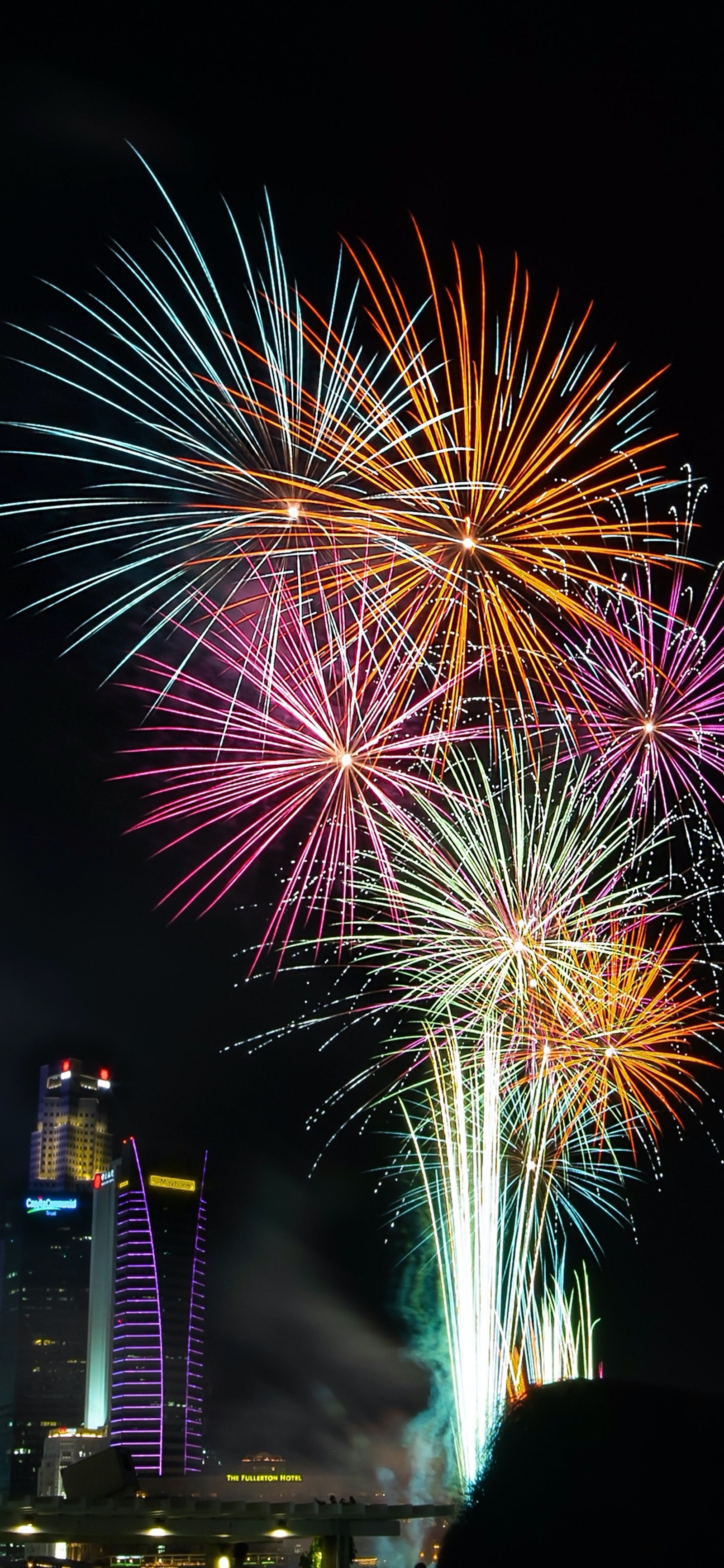 Feuerwerke leuchten am nachthimmel über einer stadt (neues jahr, weihnachten, feuerwerk, silvester, gelb)