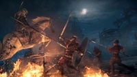 Cena de batalha épica de "Assassin's Creed Origins" apresentando um assassino montado engajado em combate em meio a chamas e caos sob um céu noturno.