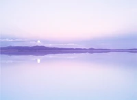 Lune violette sereine se levantant sur un lac tranquille et des montagnes