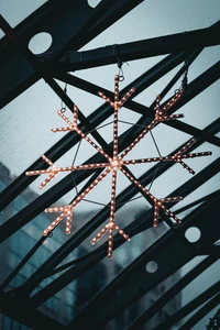 Grayscale Symmetry: Illuminated Snowflake Pendant in Modern Architecture