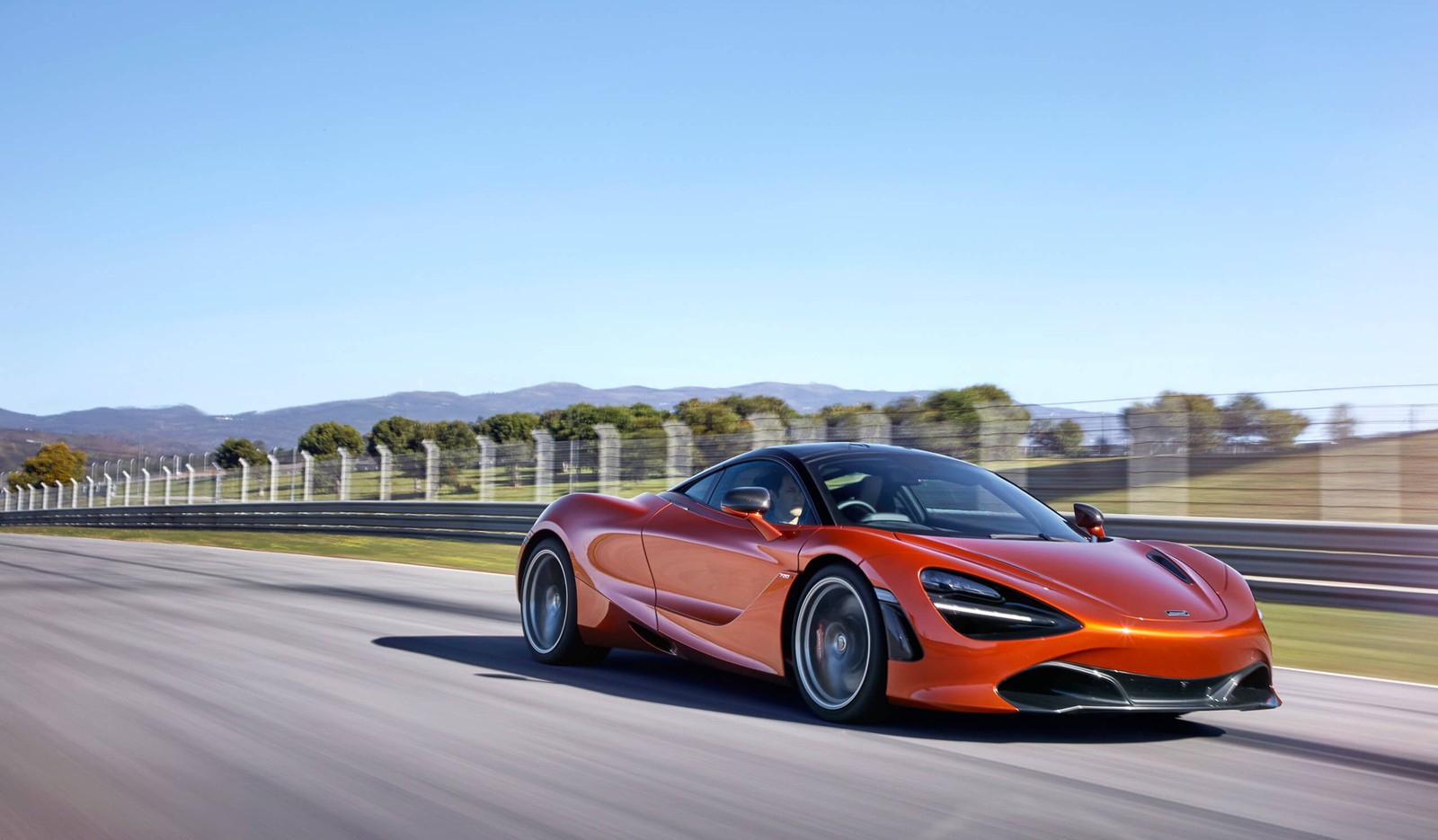 A red sports car driving on a track with mountains in the background (mclaren, car, sports car, supercar, coup)