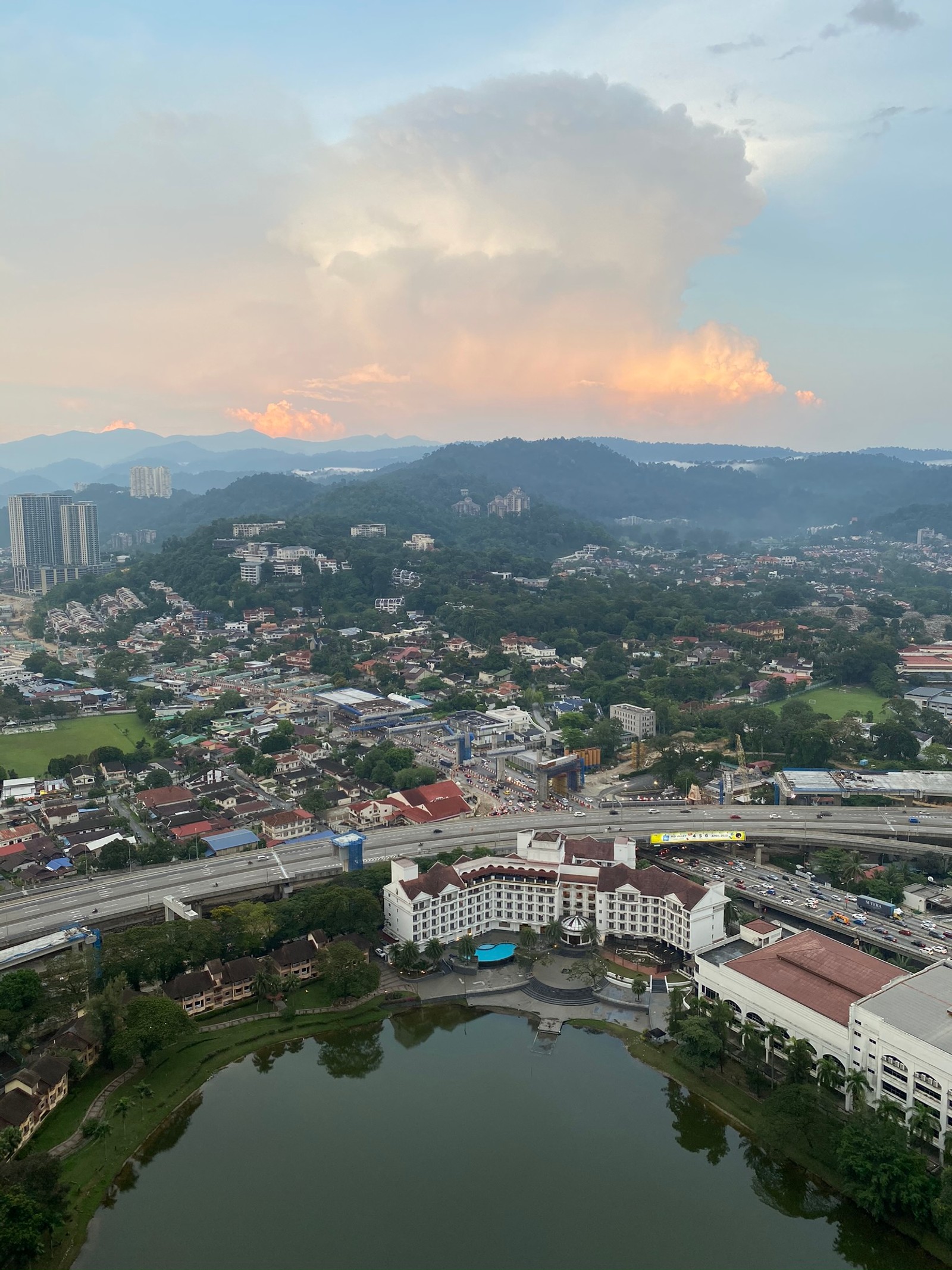 Vista aérea de uma cidade com um lago e uma ponte (nuvem, área residencial, recursos hídricos, área urbana, vizinhança)