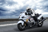 Moto sportive Suzuki Hayabusa en mouvement contre un ciel dramatique.