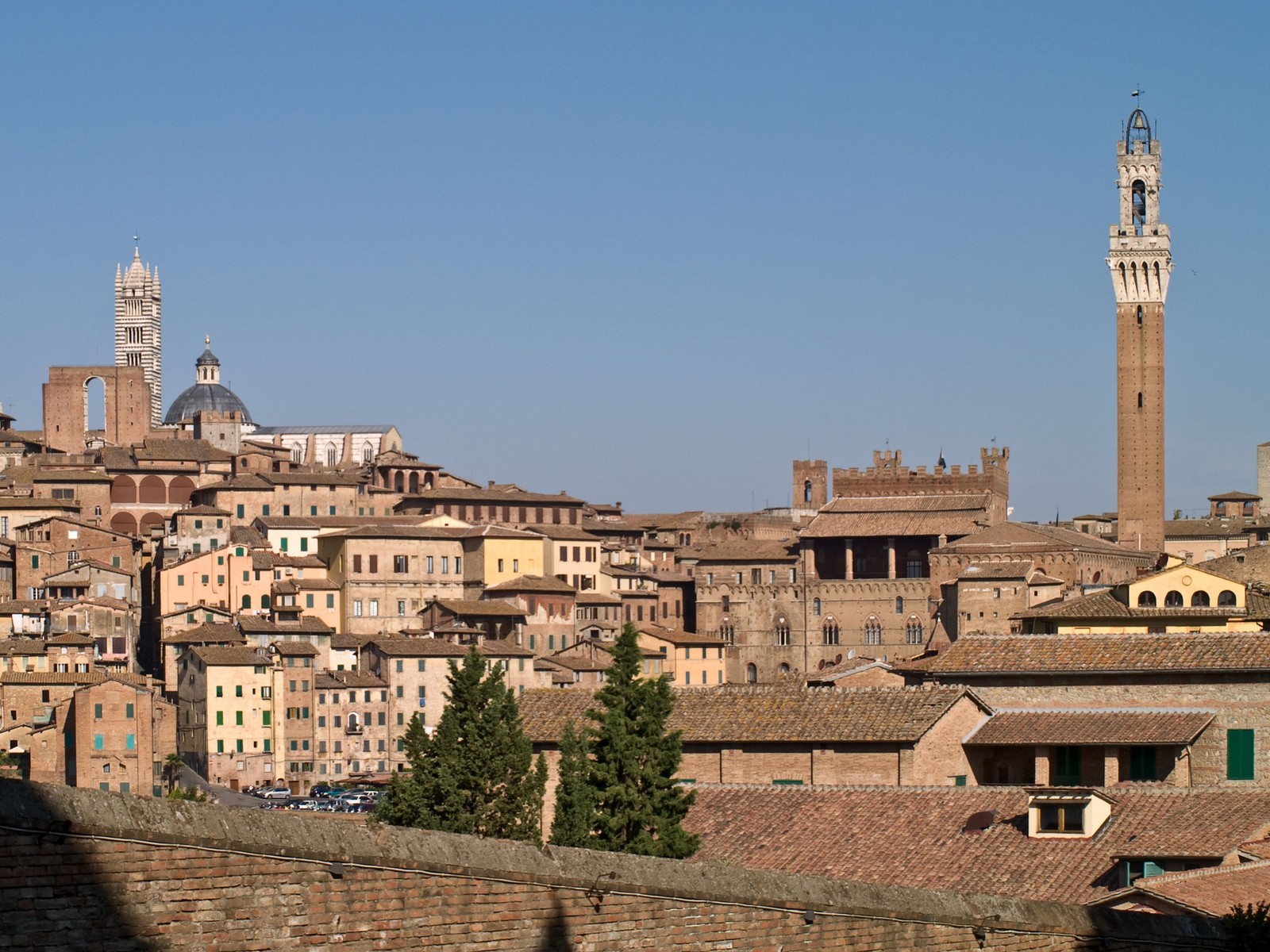 Buildings in a city with a clock tower in the middle (landmark, town, city, historic site, medieval architecture)