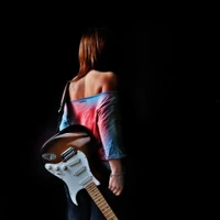 Fille avec guitare dans l'ombre artistique