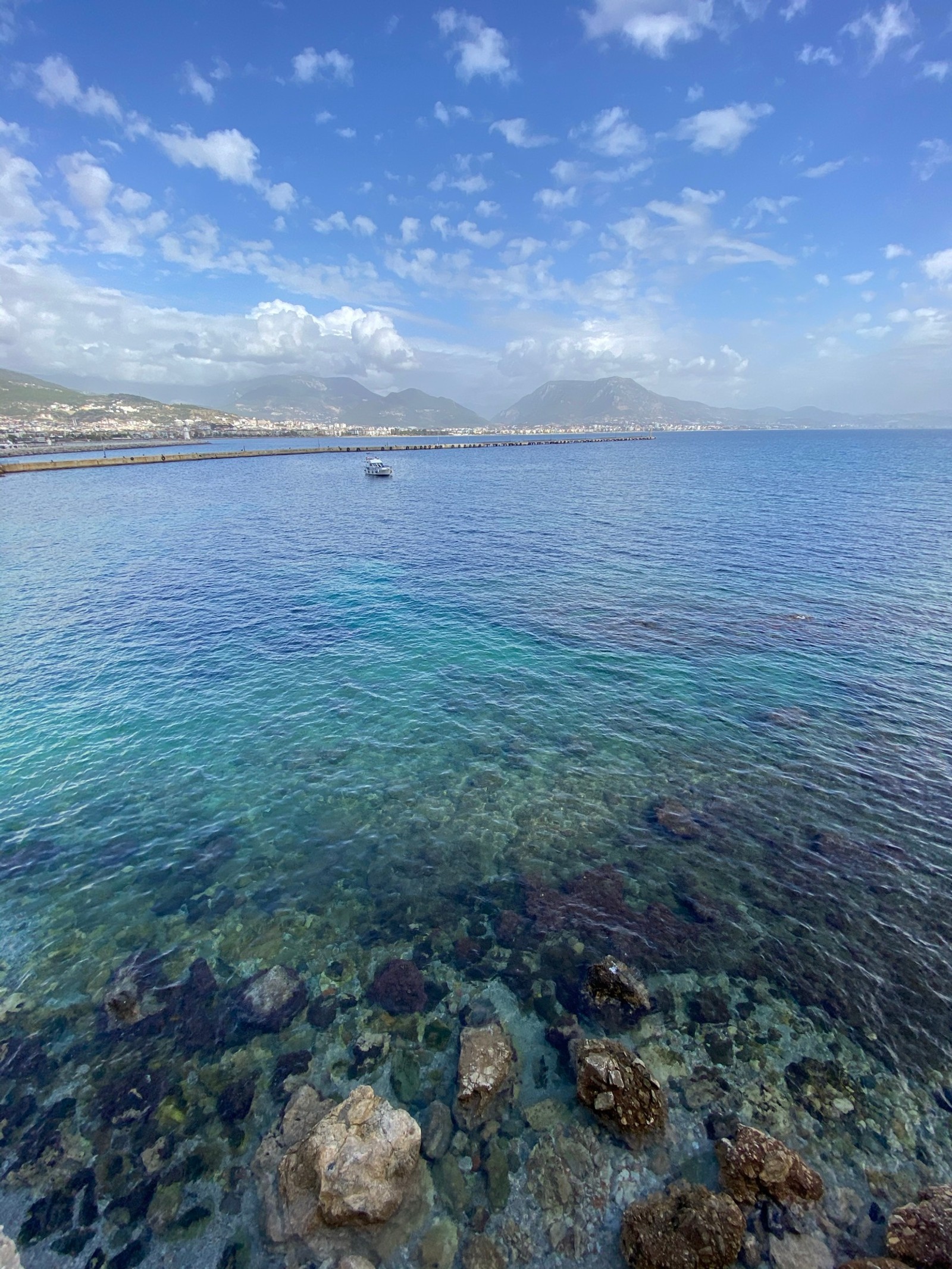 There is a boat that is out in the water near the shore (kizilkule, water, cloud, water resources, azure)