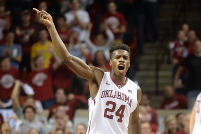 Jogador de basquete de Oklahoma celebrando um momento crucial durante um torneio universitário.