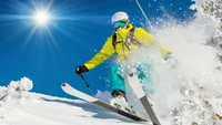 Skieur dynamique taillant dans la neige fraîche sous un ciel bleu éclatant.