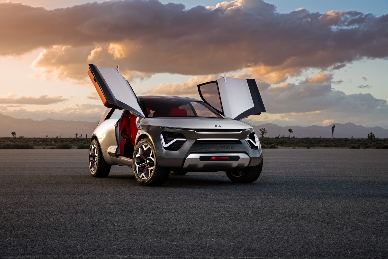 A close up of a silver car with open doors on a runway (kia motors, car, concept car, range rover, mitsubishi)