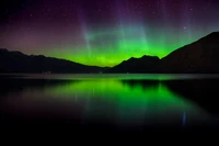 Majestätische Aurora-Reflexionen über einem ruhigen neuseeländischen See bei Dämmerung