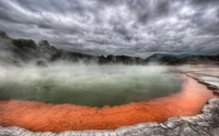 Brouillard matinal sur une source chaude des Highlands avec des bords orange vif