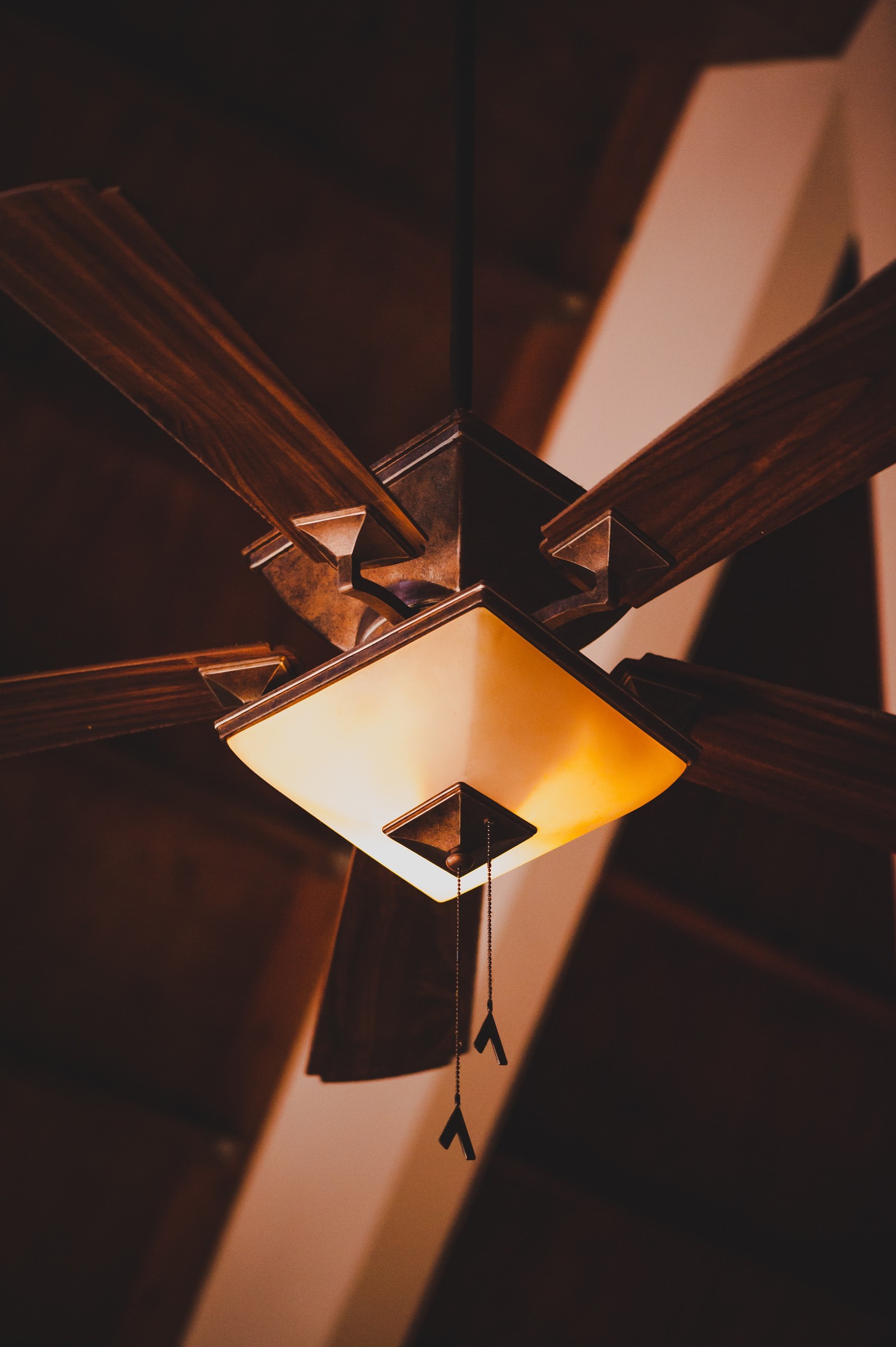 A close up of a ceiling fan with a light on it (architecture, pendant light, electric light, ceiling, lamp)