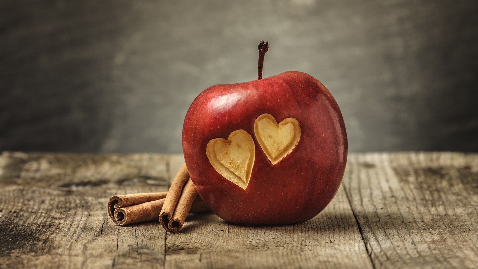 Manzanas con recortes de corazón sobre una mesa de madera (corazón, manzana, fruta, naturaleza muerta, amor)