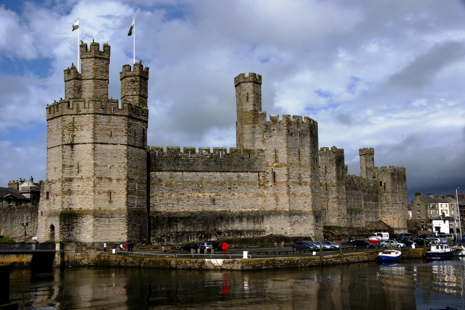 Vue aérienne d'un château avec un drapeau flottant au sommet (château, voie navigable, douves, fortification, bâtiment)