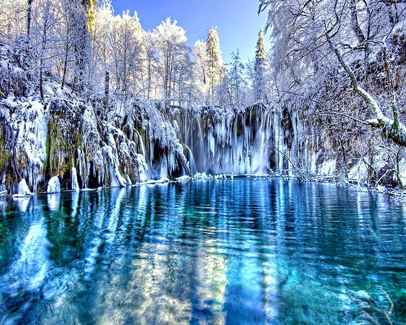 Ein großer wasserfall inmitten eines mit schnee bedeckten waldes (blau, reflexion, himmel, schnee, wasser)