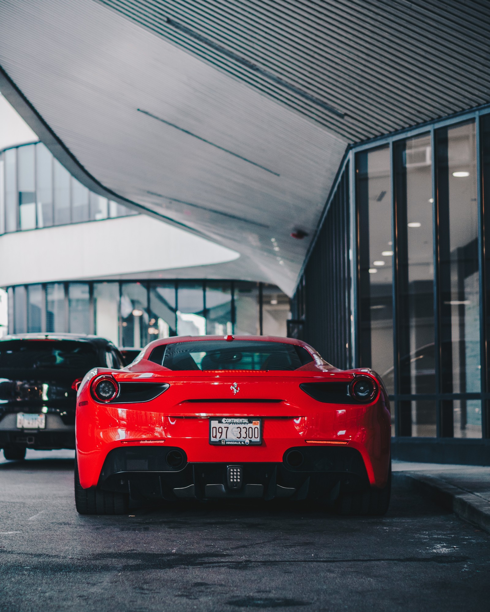 Un gros plan d'une voiture de sport rouge garée devant un bâtiment (voiture, voiture de sport, supersportive, rouge, éclairage automobile)