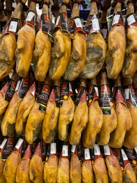 Una exhibición vibrante de jamones curados de tono amarillo, meticulosamente dispuestos para entusiastas de la cocina y coleccionistas de alimentos.