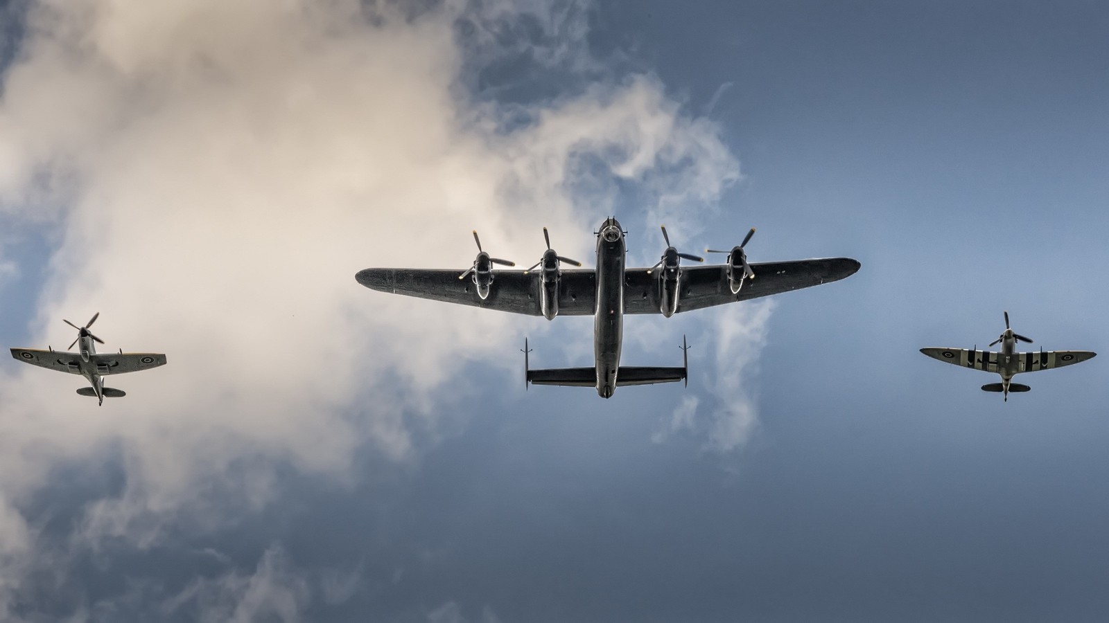 Trois avions volant en formation dans le ciel avec des nuages en arrière-plan (avro lancaster, avion, aéronef, avion militaire, aviation)