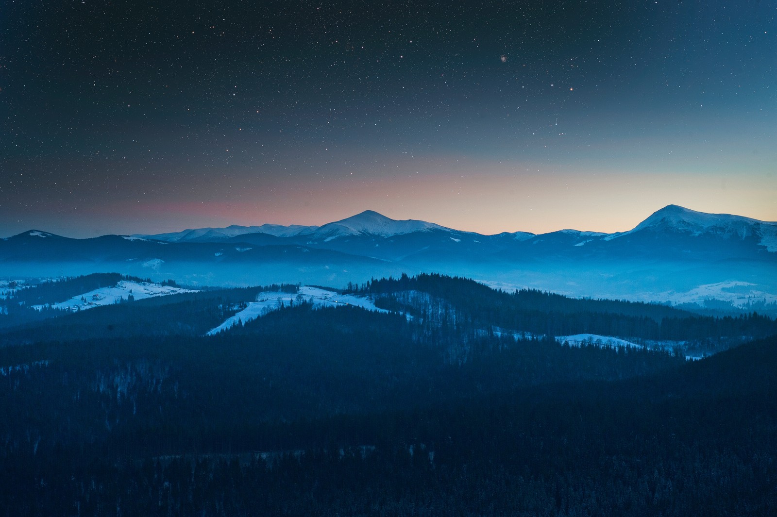 A view of a mountain range with a sky full of stars (evening, foggy, dusk, forest, mountains)