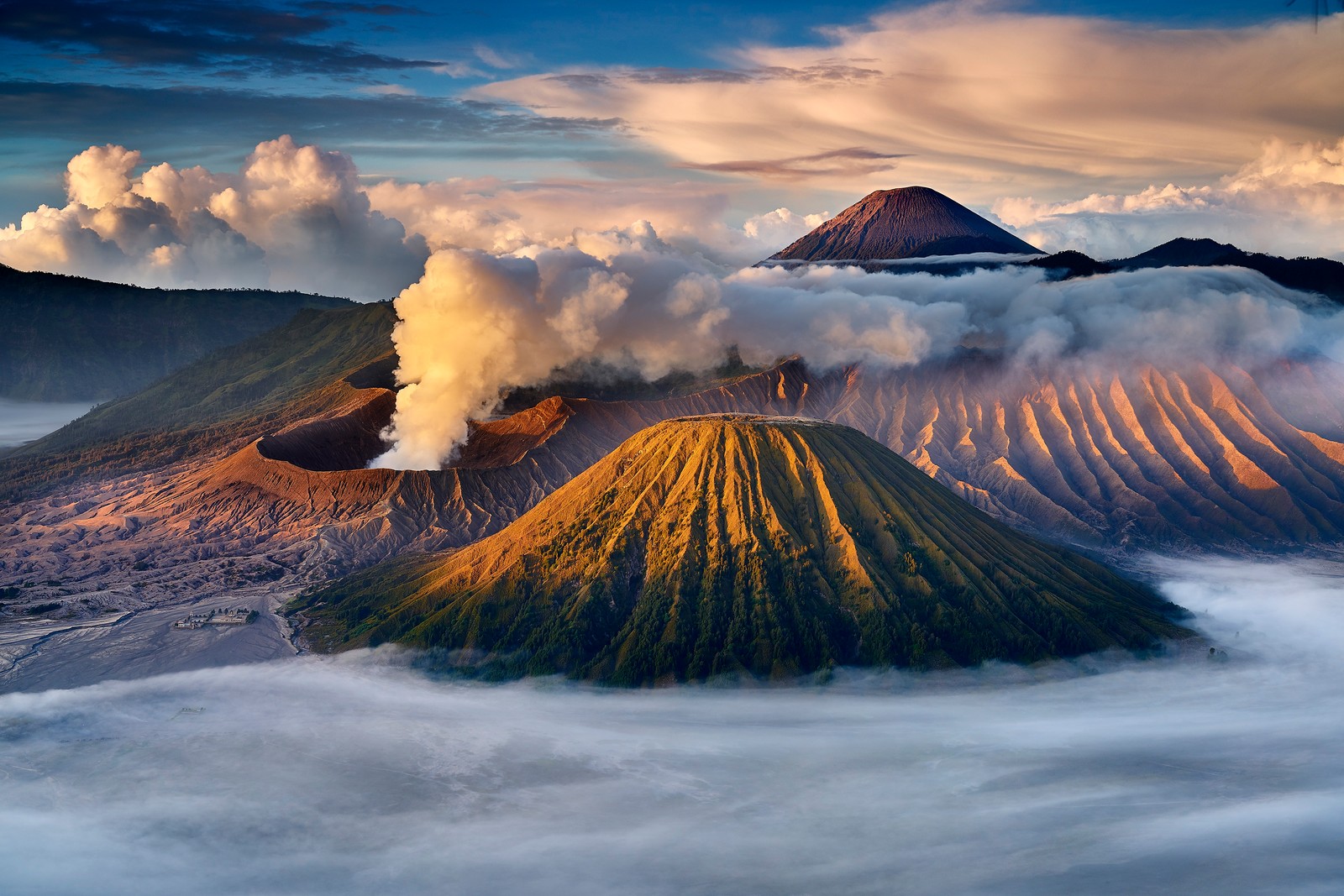 Une vue d'un groupe de montagnes avec de la vapeur qui s'en échappe (volcan, stratovolcan, forme volcanique, nuage, montagne)