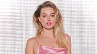 Margot Robbie dans une tenue en satin rose glamour pour une séance photo