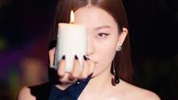 Seulgi holding a candle, exuding a captivating aura in a dark, moody setting.