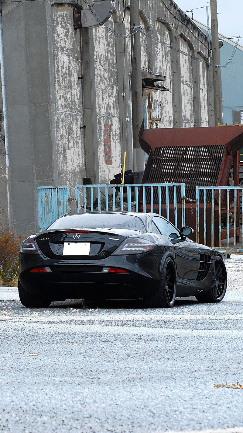 Черный спортивный автомобиль припаркован перед зданием (black colour, mercedes)